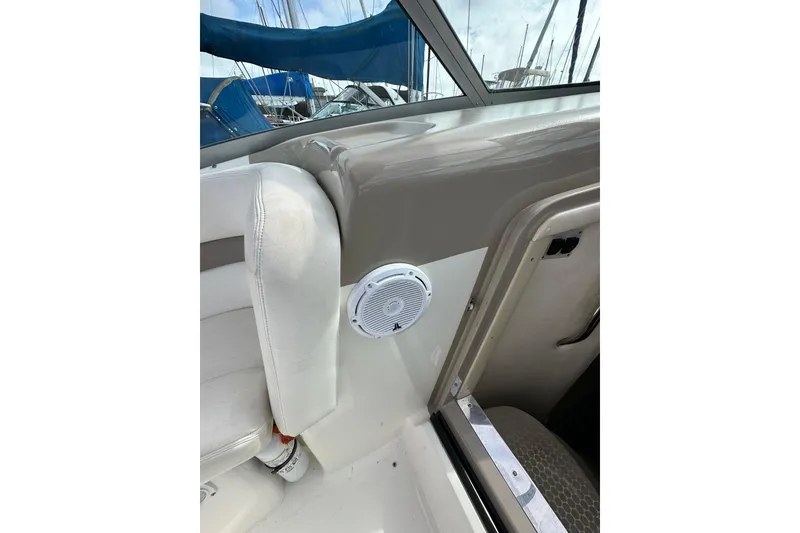 Slide: The Image of 2003 Sea Ray 320 Sundancer interior with white seating and speaker detail. - 25