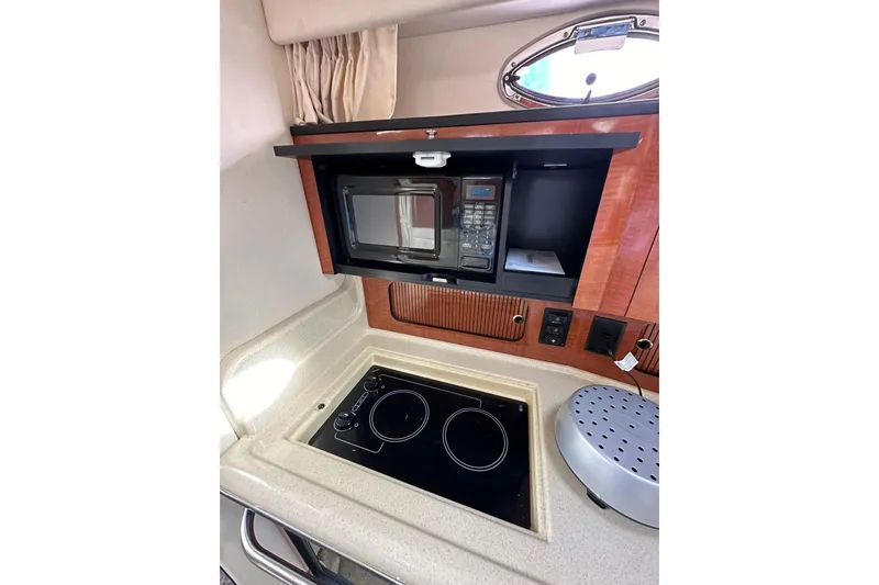 Slide: The Image of 2003 Sea Ray 320 Sundancer kitchen with microwave and stovetop. - 35