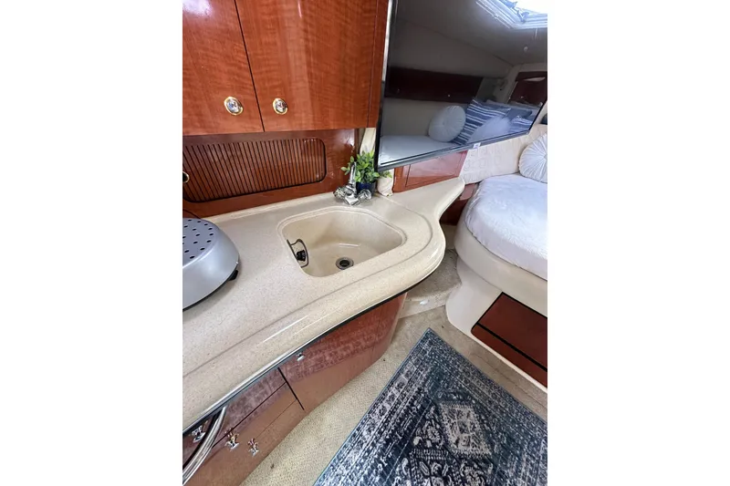 Slide: The Image of Interior of 2003 Sea Ray 320 Sundancer with kitchenette and cozy seating area. - 36