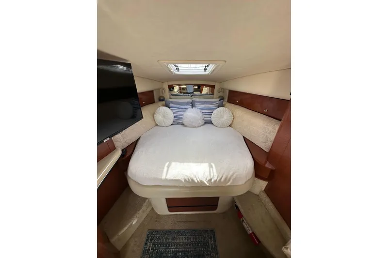 Slide: The Image of Cozy cabin interior of 2003 Sea Ray 320 Sundancer with bed and pillows. - 38