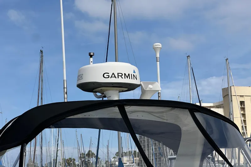 Slide: The Image of 2003 Sea Ray 320 Sundancer with Garmin radar, docked at marina under blue sky. - 4