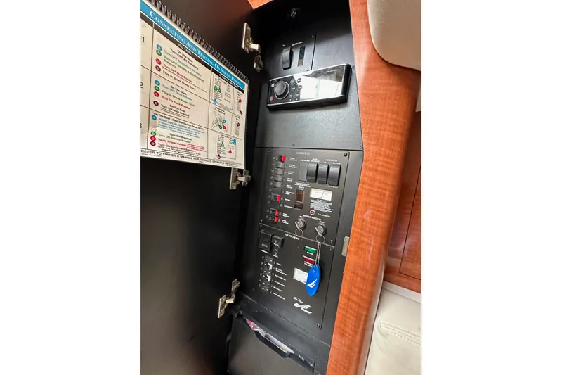 Slide: The Image of Electrical panel inside 2003 Sea Ray 320 Sundancer boat, featuring control switches and instructions. - 48