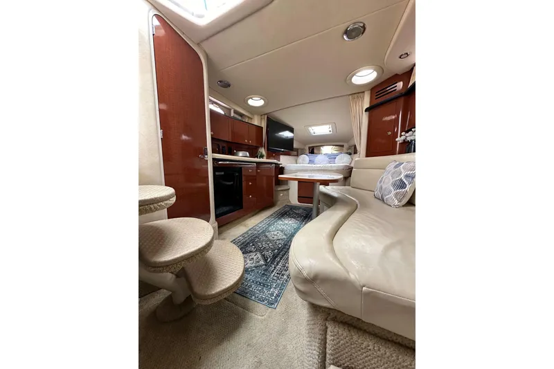 Slide: The Image of Luxurious interior of 2003 Sea Ray 320 Sundancer yacht with cozy seating and kitchenette. - 49