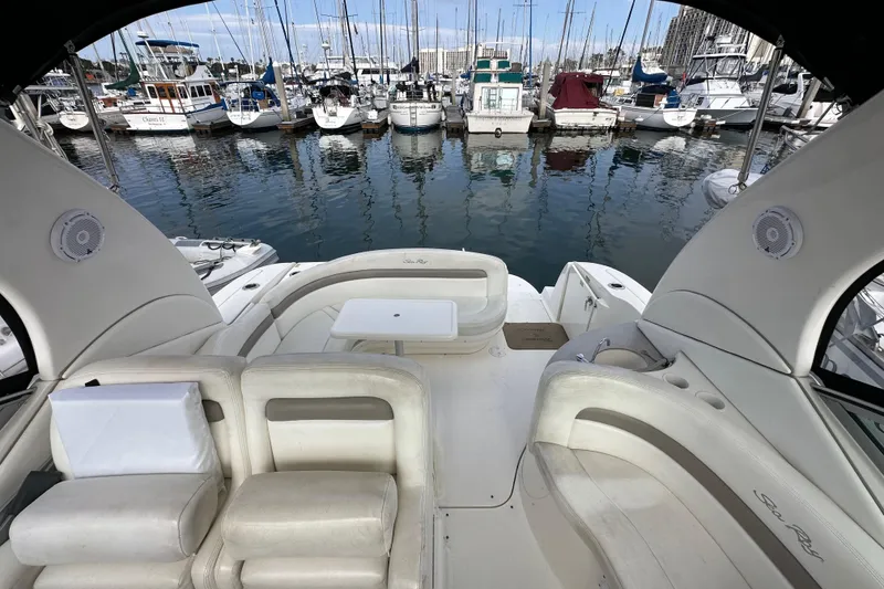 Slide: The Image of 2003 Sea Ray 320 Sundancer yacht interior with marina view, featuring white seating and table. - 50