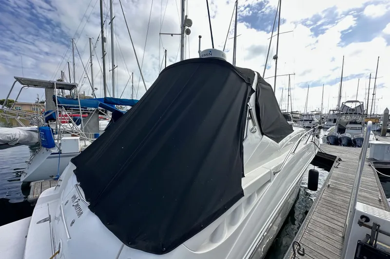 Slide: The Image of 2003 Sea Ray 320 Sundancer docked at marina with black cover. - 53