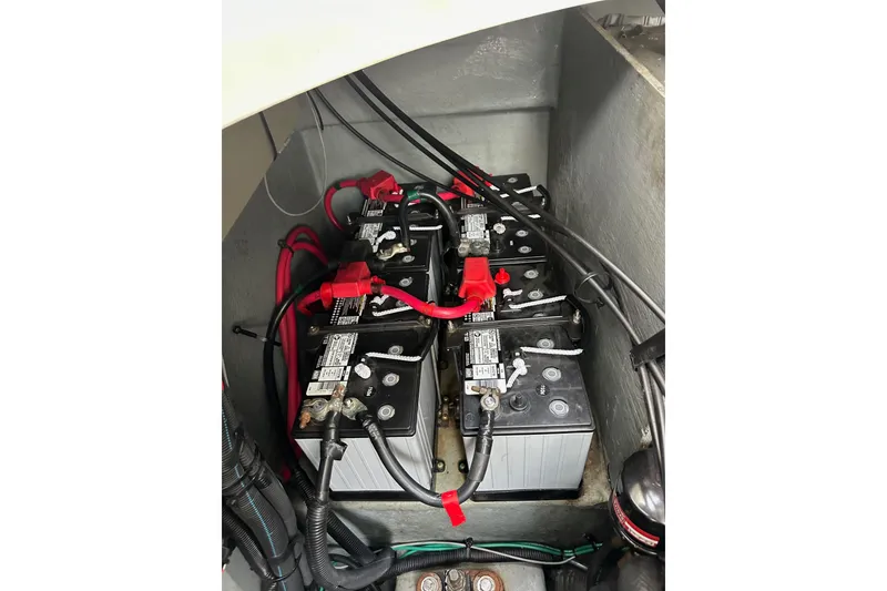 Slide: The Image of Battery compartment of a 2003 Sea Ray 320 Sundancer boat with multiple batteries and cables. - 58