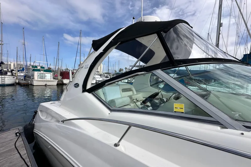 Slide: The Image of 2003 Sea Ray 320 Sundancer docked at marina, surrounded by sailboats under cloudy sky. - 6