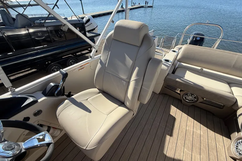 Slide: The Image of 2022 Avalon Catalina 2585 VRB boat cockpit with steering wheel and beige captain's chair. - 101