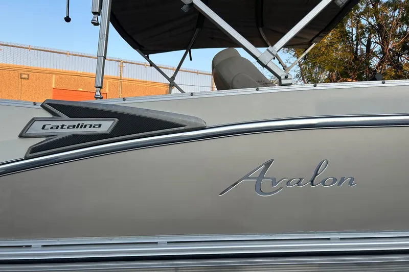 Slide: The Image of 2022 Avalon Catalina 2585 VRB pontoon boat on trailer, featuring sleek design and canopy. - 2