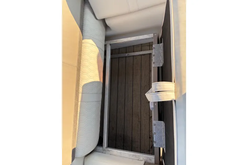 Slide: The Image of 2022 Avalon Catalina 2585 VRB boat seat storage compartment with metal hinges and textured upholstery. - 60
