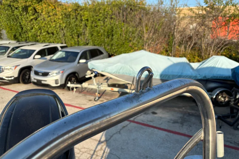 Slide: The Image of 2022 Avalon Catalina 2585 VRB boat railing with parked cars and covered boats in background. - 64