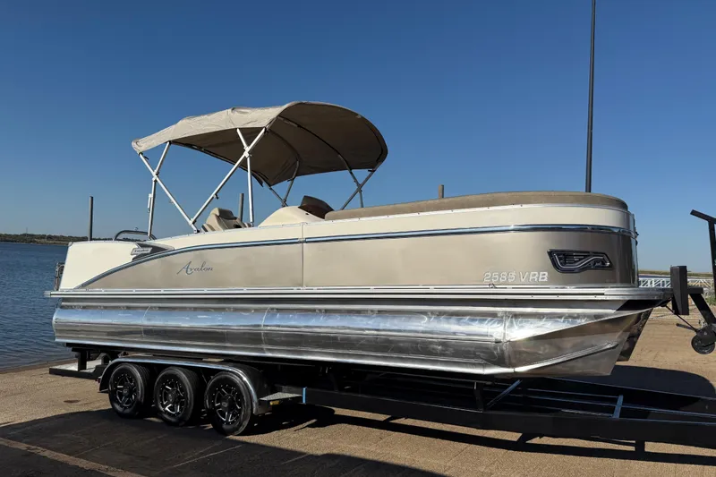 Slide: The Image of 2022 Avalon Catalina 2585 VRB pontoon boat on trailer by the water. - 70