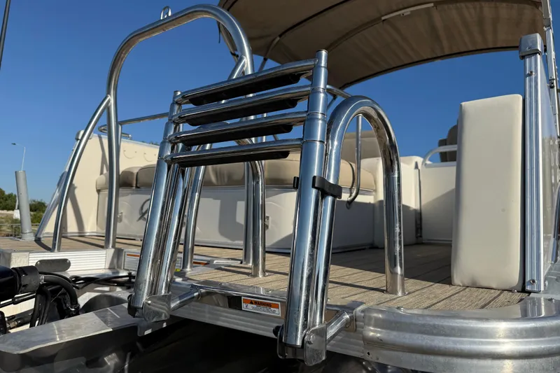 Slide: The Image of Suzuki four-stroke outboard motor on 2022 Avalon Catalina 2585 VRB boat by the water. - 82