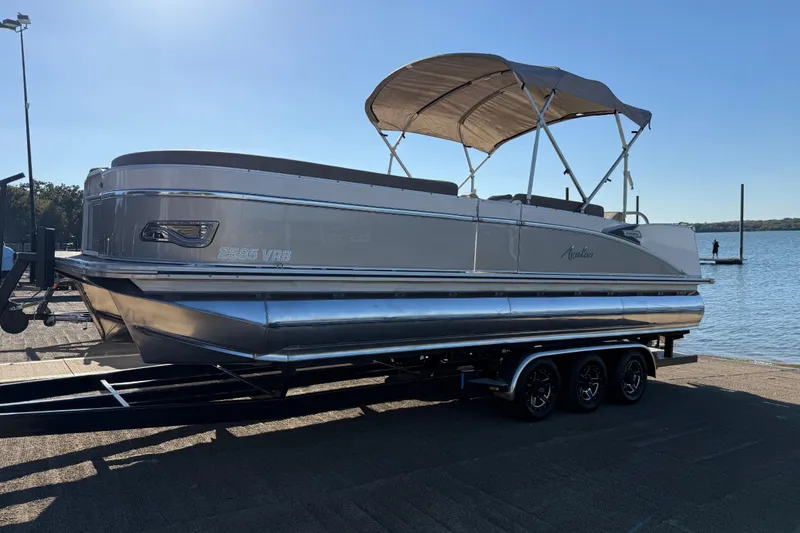Slide: The Image of 2022 Avalon Catalina 2585 VRB pontoon boat on trailer by the water. - 91