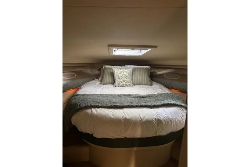 Slide: The Image of Cozy cabin interior of 1998 Sea Ray 400 Express Cruiser with plush bedding and pillows. - 10