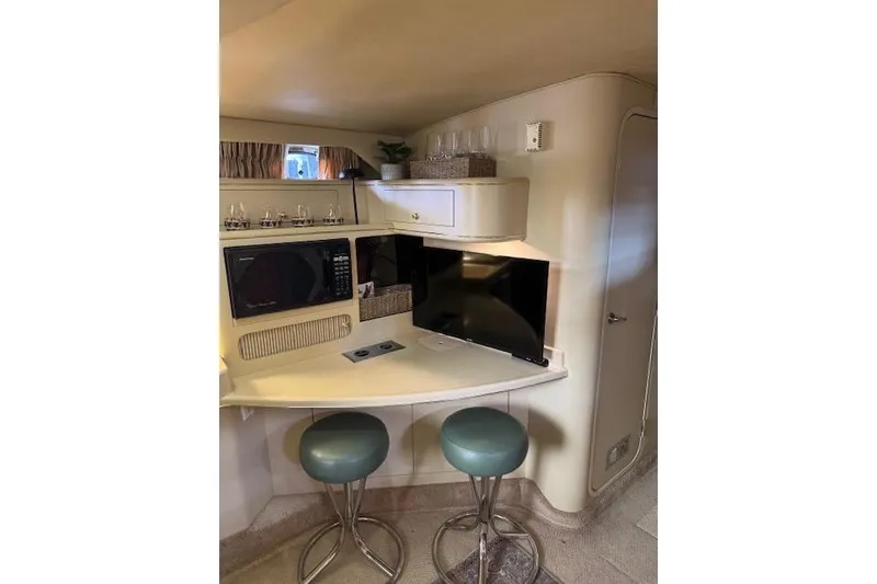 Slide: The Image of Interior of 1998 Sea Ray 400 Express Cruiser with TV, microwave, and bar stools. - 11
