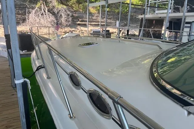 Slide: The Image of 1998 Sea Ray 400 Express Cruiser docked, showcasing sleek design and polished railings. - 6