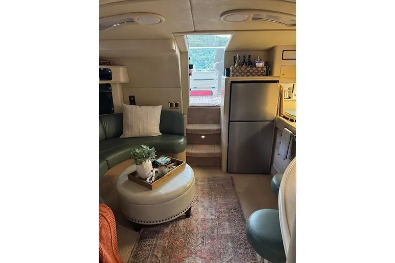 Slide: The Image of Interior of 1998 Sea Ray 400 Express Cruiser with seating, table, and kitchenette. - 7