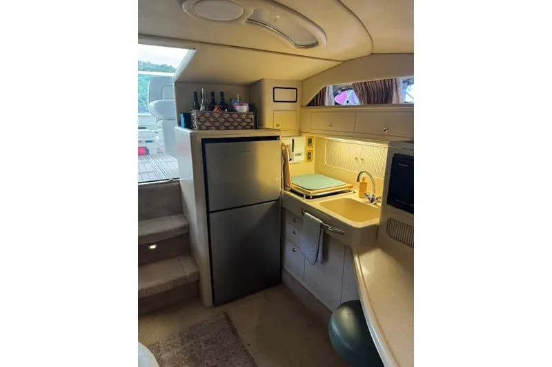 Slide: The Image of Interior of 1998 Sea Ray 400 Express Cruiser with kitchenette and refrigerator. - 9