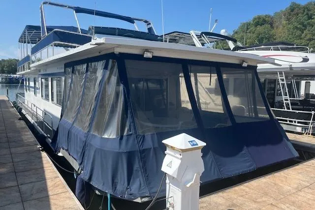 The Image of 1985 Jamestowner 16 x 63 houseboat docked with blue canopy and upper deck. - 0