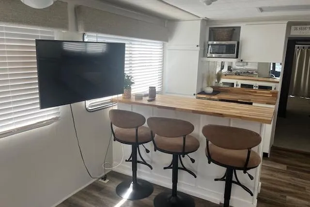 Slide: The Image of 1985 Jamestowner houseboat interior with bar stools, TV, and modern kitchen area. - 11