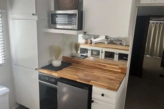 Slide: The Image of Modern kitchen in a 1985 Jamestowner 16 x 63 houseboat with wood countertops and stainless appliances. - 14