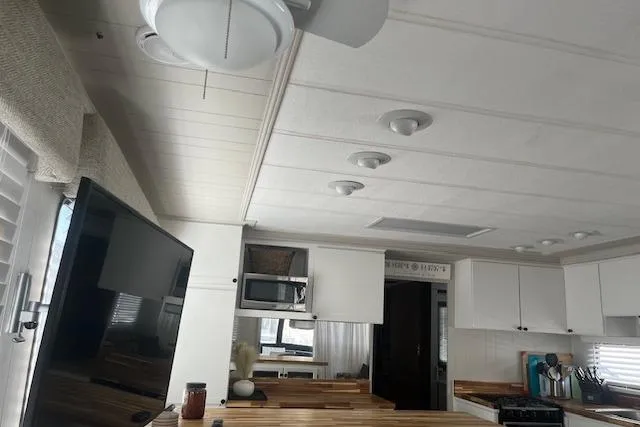 Slide: The Image of Interior of 1985 Jamestowner 16 x 63 houseboat with modern kitchen and ceiling fan. - 16