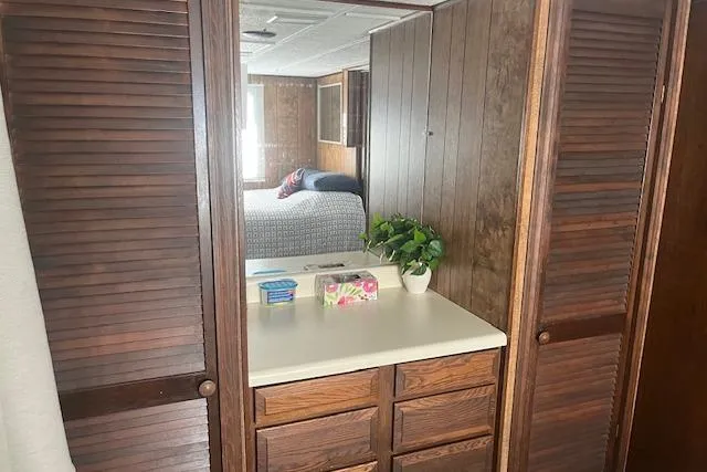 Slide: The Image of 1985 Jamestowner houseboat interior with wood paneling, vanity, and cozy bedroom view. - 21