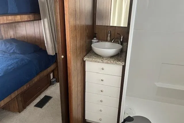 Slide: The Image of 1985 Jamestowner 16 x 63 houseboat interior with bedroom and bathroom sink. - 23