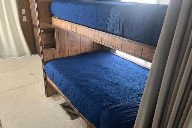 Slide: The Image of Bunk beds with blue bedding in a 1985 Jamestowner 16 x 63 houseboat interior. - 25