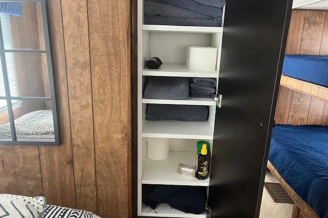 Slide: The Image of 1985 Jamestowner houseboat interior with wooden walls, open storage cabinet, and bunk beds. - 26