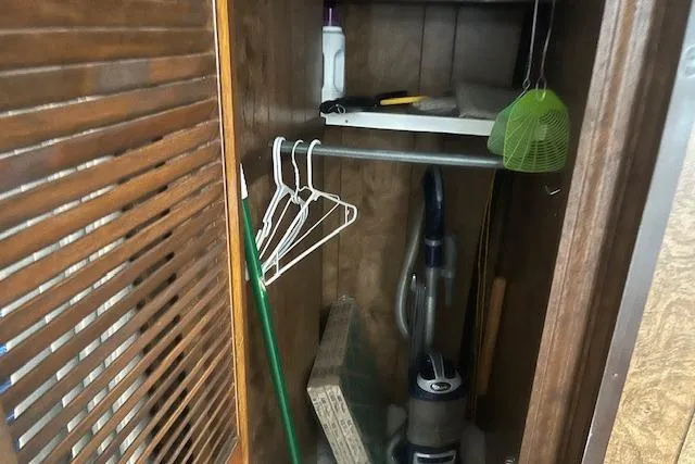 Slide: The Image of Small storage closet on 1985 Jamestowner houseboat with cleaning supplies and hangers. - 27