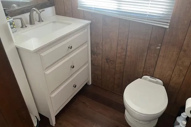 Slide: The Image of 1985 Jamestowner houseboat bathroom with wood paneling, white vanity, and compact toilet. - 28