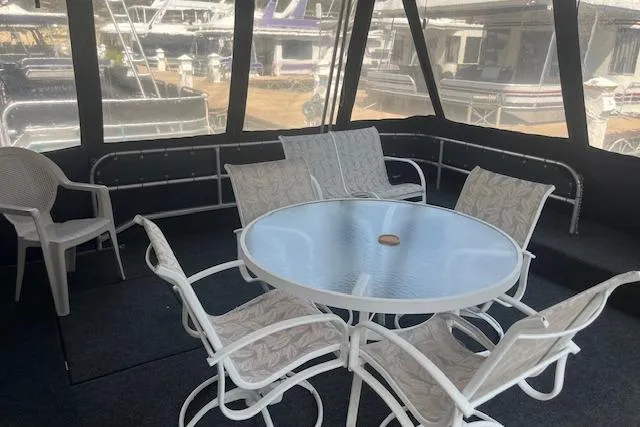 Slide: The Image of 1985 Jamestowner 16 x 63 houseboat interior with white patio furniture and glass table. - 3