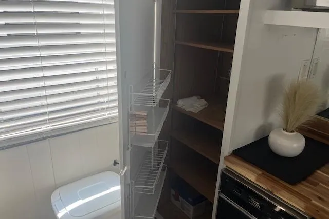 Slide: The Image of 1985 Jamestowner houseboat interior with bathroom, shelves, and window blinds. - 30