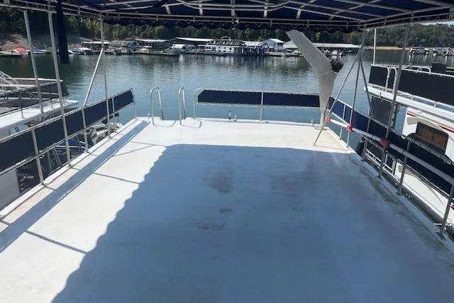 Slide: The Image of 1985 Jamestowner 16 x 63 houseboat deck with canopy, overlooking serene marina. - 32