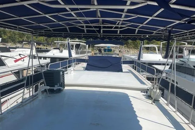 Slide: The Image of 1985 Jamestowner 16 x 63 houseboat with spacious deck and canopy, docked among other boats. - 33