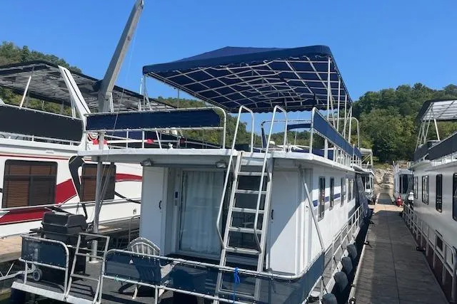 Slide: The Image of 1985 Jamestowner 16 x 63 houseboat docked with blue canopy and ladder. - 34