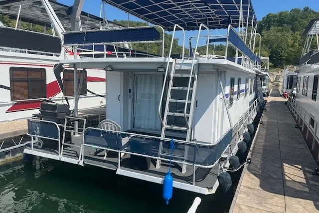 Slide: The Image of 1985 Jamestowner 16 x 63 houseboat docked, featuring upper deck and outdoor seating. - 35