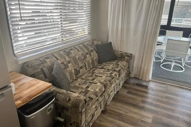 Slide: The Image of 1985 Jamestowner 16 x 63 houseboat interior with patterned sofa, wooden floor, and outdoor seating. - 9