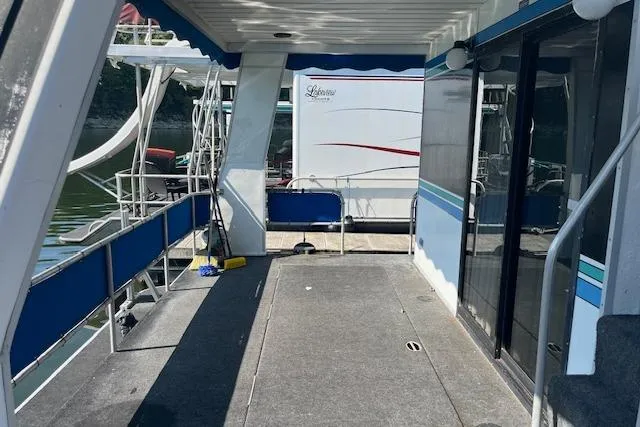 Slide: The Image of 1992 Jamestowner 16x72 houseboat deck with blue accents and sliding glass doors. - 18