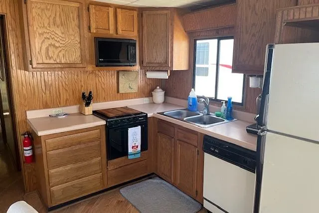 Slide: The Image of 1992 Jamestowner 16x72 houseboat kitchen with wooden cabinets, appliances, and dual sink. - 8