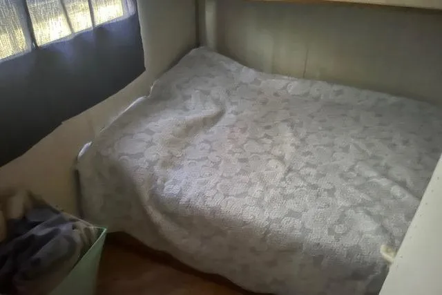 Slide: The Image of Cozy bed inside a 1992 Jamestowner 16x72 houseboat cabin. - 14