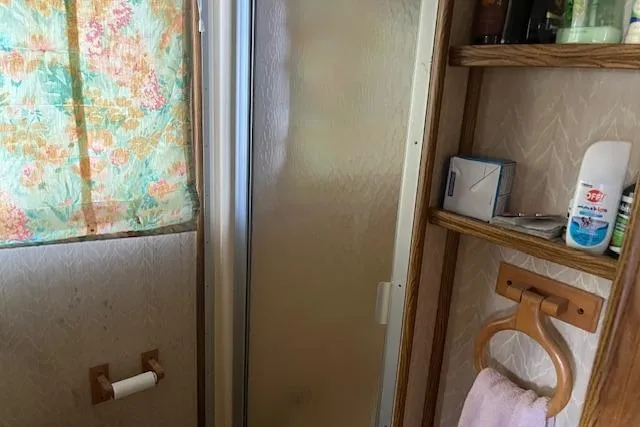 Slide: The Image of Bathroom interior of 1992 Jamestowner 16x72 houseboat with shower and wooden shelves. - 15