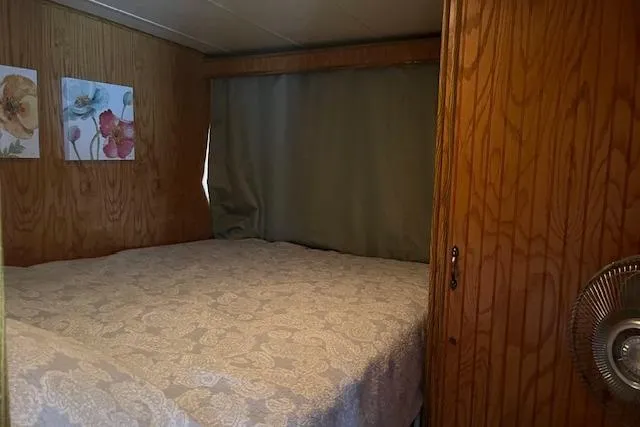Slide: The Image of Cozy bedroom in 1992 Jamestowner 16x72 houseboat with wood paneling and floral decor. - 17