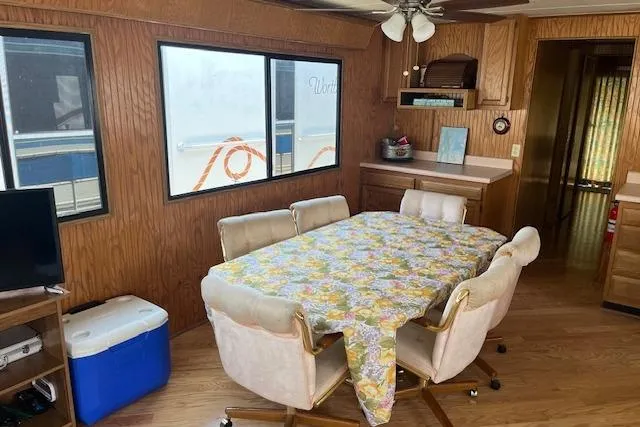 Slide: The Image of Dining area inside 1992 Jamestowner 16x72 houseboat with floral tablecloth and wooden interior. - 6