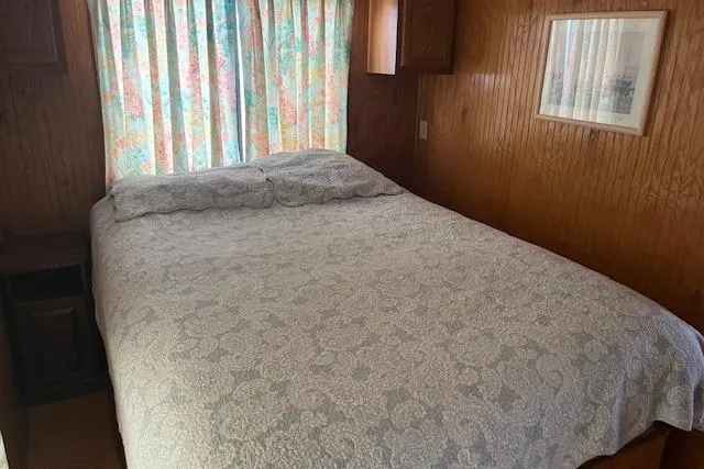 Slide: The Image of Cozy bedroom in 1992 Jamestowner 16x72 houseboat with floral curtains and wood paneling. - 9