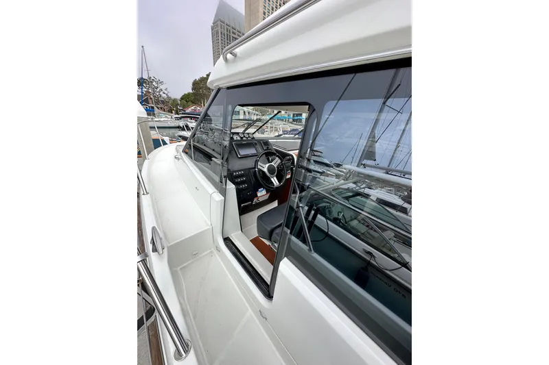 Slide: The Image of 2015 Jeanneau NC11 boat with sleek design and modern cockpit, docked at marina. - 15