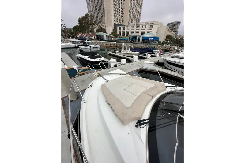 Slide: The Image of 2015 Jeanneau NC11 yacht docked in a marina with cityscape background. - 18