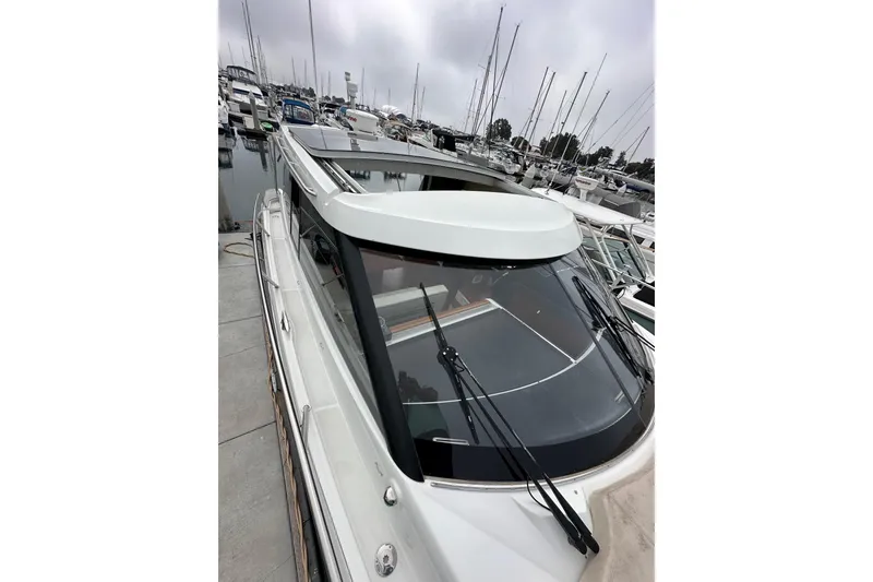 Slide: The Image of 2015 Jeanneau NC11 yacht docked in a marina, showcasing sleek design and modern features. - 22